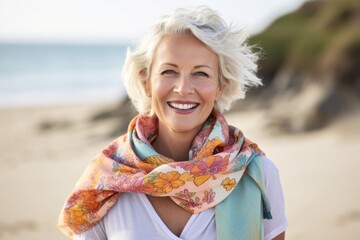 Portrait Of Mature Woman Wearing Scarf Relaxing On Beach