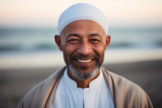 Portrait of smiling middle eastern man on the beach at sunset time