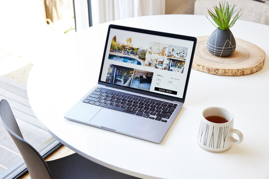 Computer on dining room table showing a vacation rental listing