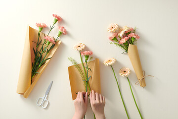Female florist wrapping in craft paper beautiful bouquets