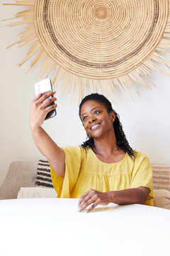 Happy mature Black woman taking a selfie of herself on phone