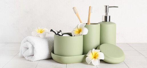 Set of bathing cosmetics and accessories on light tile table