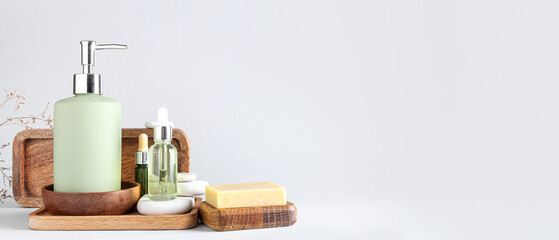 Bottle with liquid soap and essential oils on light background with space for text