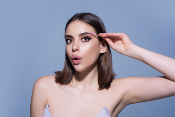 Fototapeta premium Woman comb eyebrows with eyebrow brush. Care for brows, eyebrows lamination. Brow beauty procedures. Beautiful woman with long eyelashes, eyebrows.