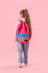 Little schoolgirl with backpack on pink background, back view