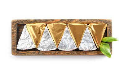 Board with triangles of tasty processed cheese in foil on white background
