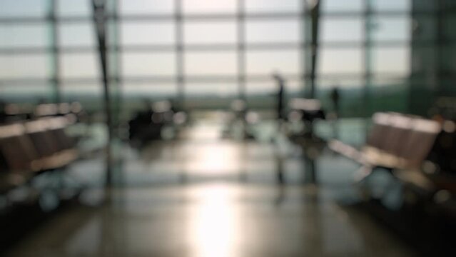 Defocused Silhouettes of passengers waiting and walking in front of the boarding gates at Izmir Airport.
