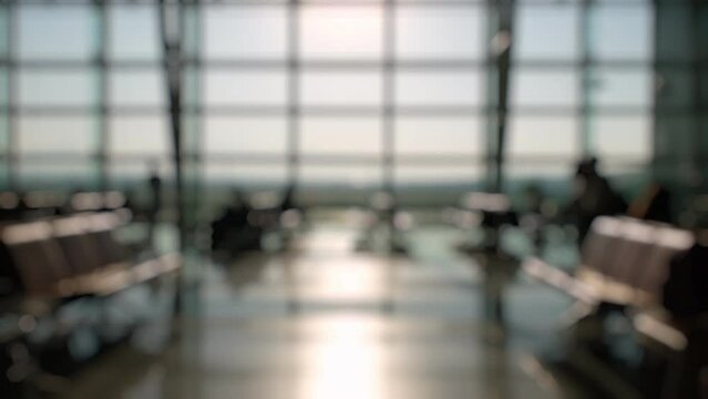 Defocused Silhouettes of passengers waiting and walking in front of the boarding gates at Izmir Airport.