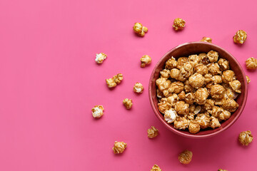 Bowl with tasty popcorn on pink background