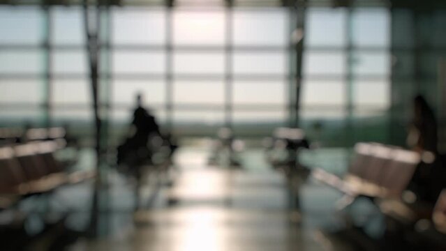 Defocused Silhouettes of passengers waiting and walking in front of the boarding gates at Izmir Airport.