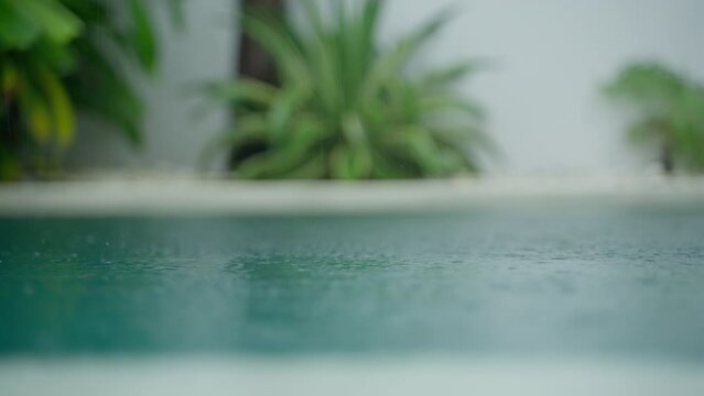Rain falls in a tropical luxury villa with swimming pool in Bali. Close up