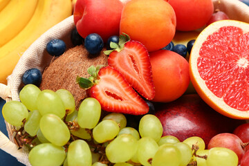 Wicker basket with different fresh fruits, closeup