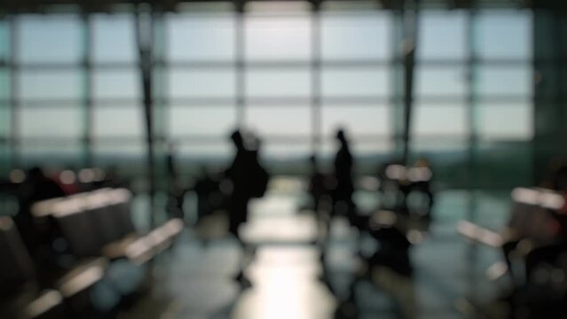 Defocused Silhouettes of passengers waiting and walking in front of the boarding gates at Izmir Airport.