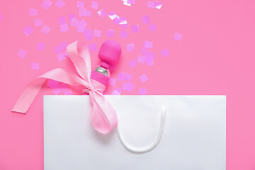 Shopping bag with vibrator on pink background