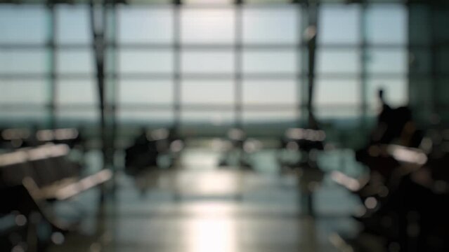 Defocused Silhouettes of passengers waiting and walking in front of the boarding gates at Izmir Airport.