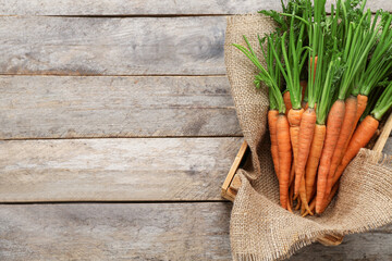 Tasty fresh carrots on wooden background