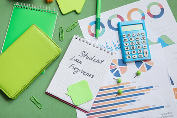 Notepad with text STUDENT LOAN FORGIVENESS, calculator, charts and stationery on green background