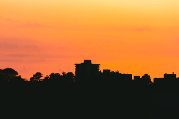 Obraz premium Sunset city silhouette with the orange sky above the buildings from puerto rico golden hour time 