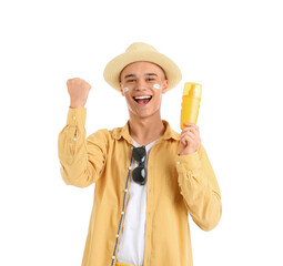 Happy young man with sunscreen cream on his face against white background