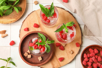 Glasses of fresh raspberry lemonade with mint on white tile background
