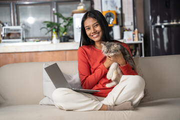 Beautiful asian Woman holding Persia cat in hand at home. Woman look happiness to stay and enjoy...