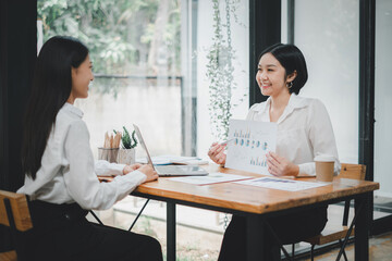 Female operations manager holds meeting presentation for a team of economists. Asian woman uses business paper with Growth Analysis, Charts, Statistics and Data.