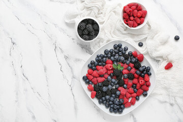 Composition with different fresh berries on light background