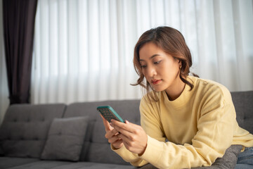 Woman asian using smart phone and Browsing Internet and shopping  on sofa at home