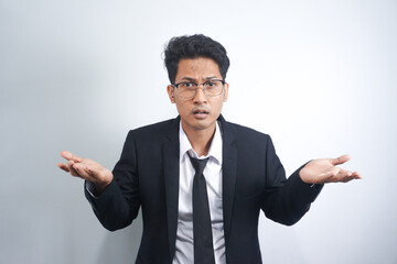 I don't know, who cares. Portrait of confused Asian man with in suit shrugging shoulders, making no idea gesture, whatever. indoor studio shot isolated on white background - Powered by Adobe