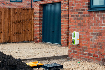 Electric vehicle domestic charging point installed outside of the house on new housing development...