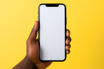 hand holding smart phone yellow background