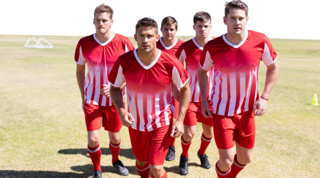 Digital png photo of caucasian male football players running at stadium on transparent background