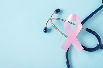 Breast cancer awareness pink ribbon with stethoscope on blue background