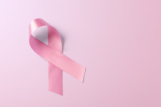 Breast cancer awareness ribbon on light pink background with copy space