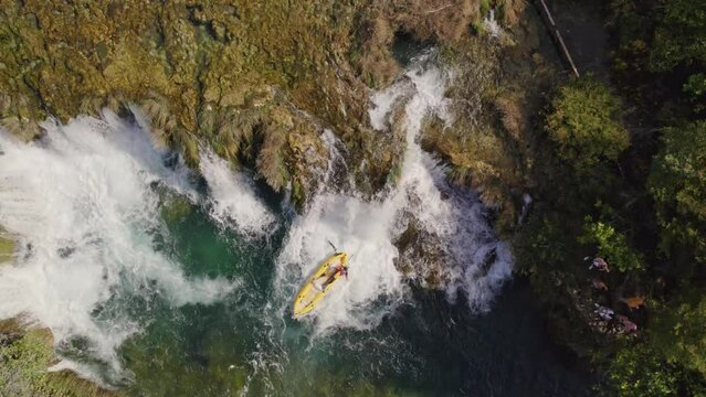 Top down of yellow kayak that goes down small waterfall at zrmanja river Croatia, aerial