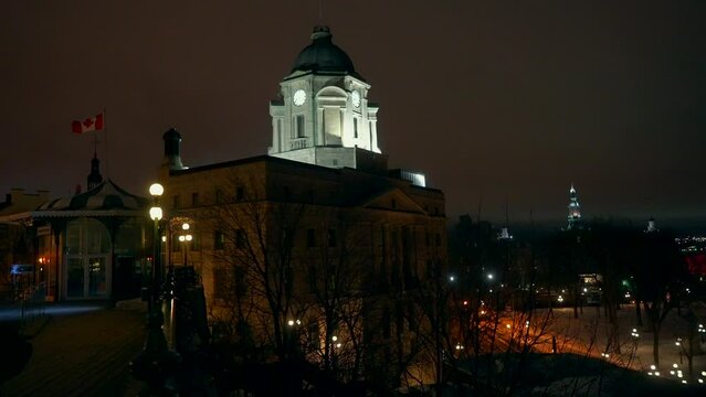 Cinematic Quebec City center Canada cold winter evening night time downtown center Quai Lookout Point St Lawrence River street church peaceful snow on ground flag blowing in wind slow pan a movement