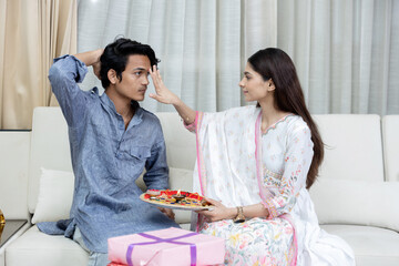Indian good looking young brother and sister celebrating Raksha Bandhan / Rakhi festival or on Bhai...