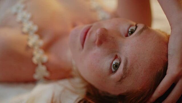 Close up of a beautiful red haired woman looking romantically and wearing lingerie