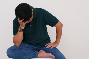 Man sitting alone with one hand supporting his face. looking depressed