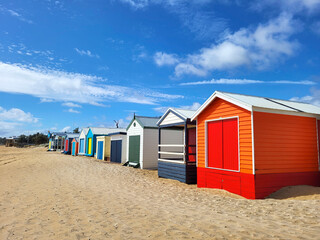 Fototapeta na wymiar Bright colourful beach huts At Mount Marth on Mornington Peninsular. The bathing boxes are very expensive and are very rarely for sale. There are over 1000 huts on the peninsula from Rosebud to Mount 