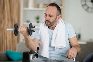 man in wheelchair lifting weights