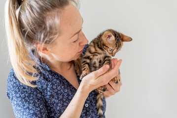 Close up of a woman happy playing with a kitten	
