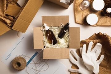 Beauty box with serum bottles on shredded white paper. Eco-friendly cardboard gift box with zero-waste cosmetics products. Online retail store orders in the delivery service warehouse.