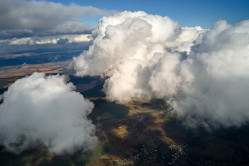 Fototapeta na wymiar Aerial view at high altitude of earth covered with puffy cumulus clouds forming before rainstorm
