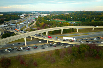 Fototapeta premium Aerial view of american freeway intersection with fast moving cars and trucks. USA transportation infrastructure concept