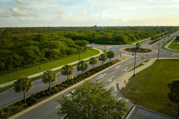 Aerial view of american suburban area with rural road roundabout intersection with moving cars...