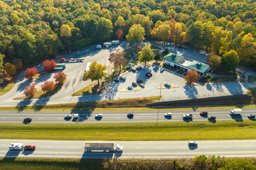 Aerial view of big rest area near busy american freeway with fast moving cars and trucks....