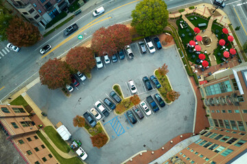 Aerial view of many colorful cars parked on parking lot on apartment building backyard. Place for vehicles in front of residential condo