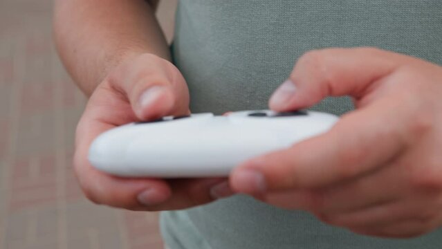 close-up of male hands operate the joystick of a children's car on the control panel in the park