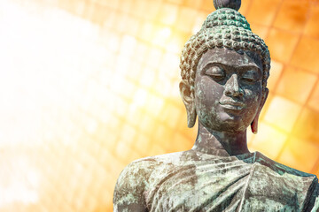 Buddha face isolated on yellow background, big bronze Buddha